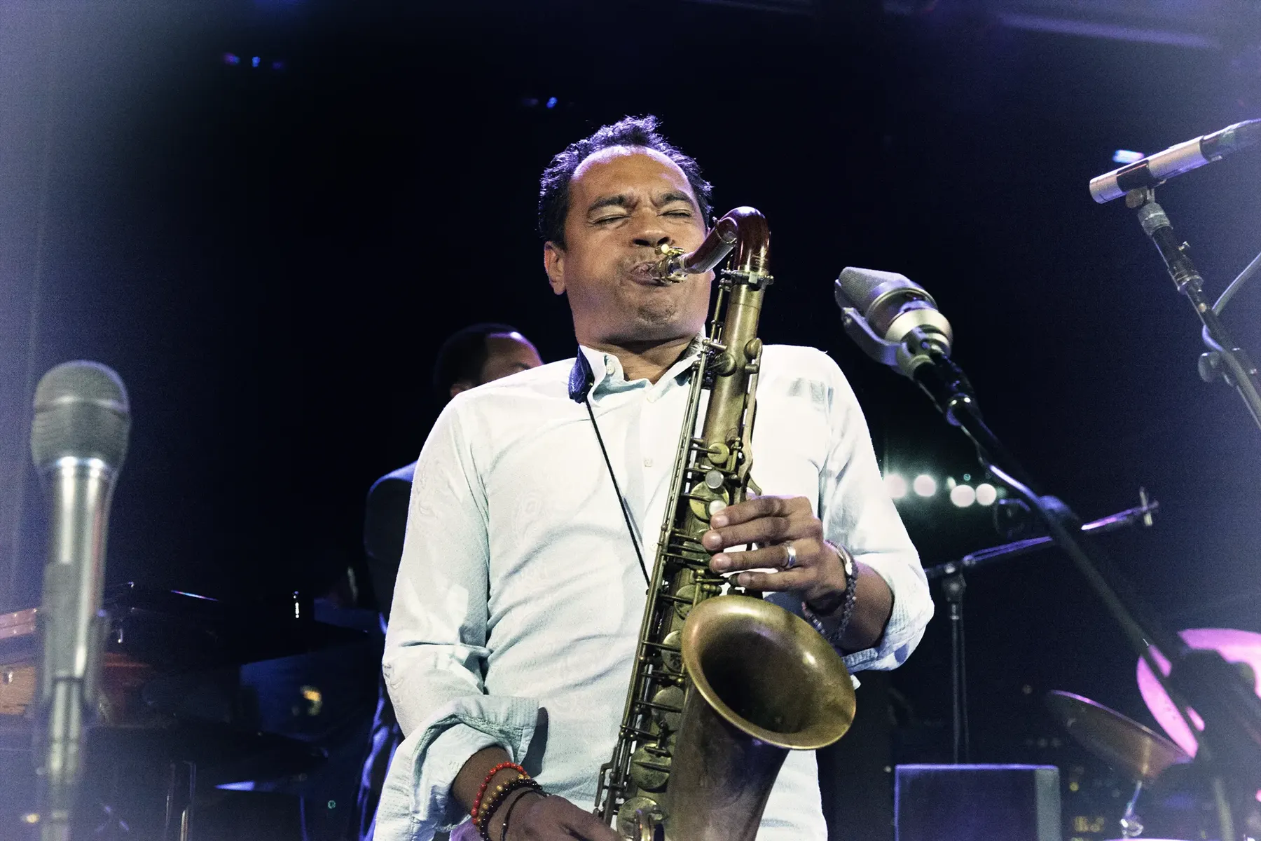 Jay Rodriguez Sierra playing alto saxophone on a club stage.